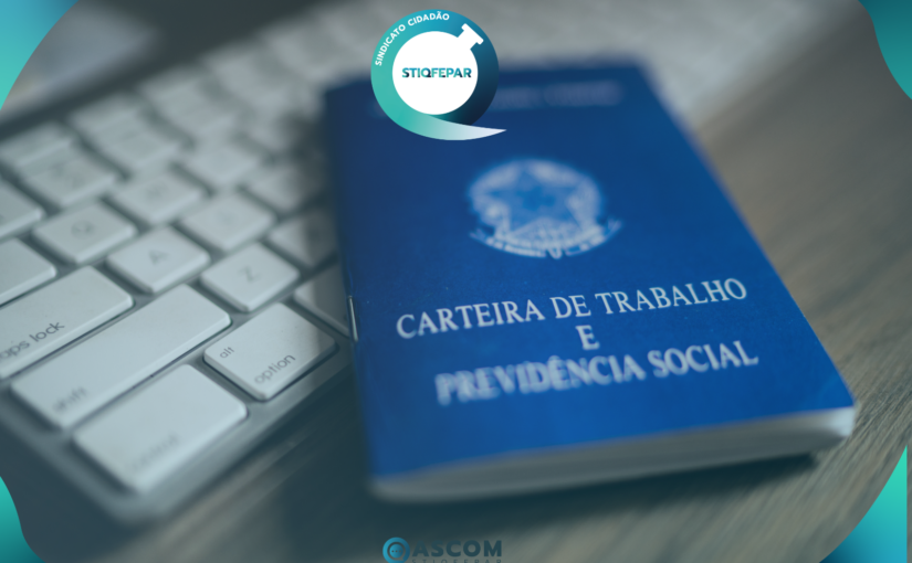 Carteira de trabalho azul sobre um teclado de computador.